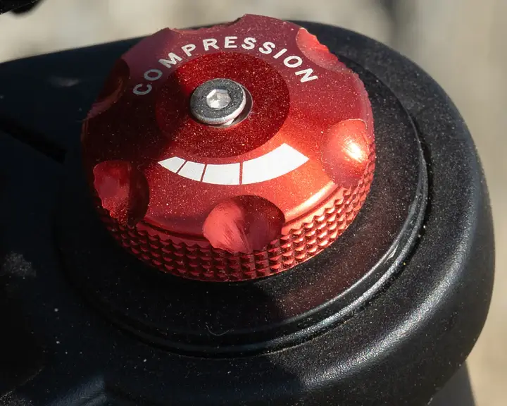 GT54 PRO elektrinis motociklas 1500W priekinės pakabos kompresijos reguliavimo rankenėlė (compression knob), leidžianti tiksliai sureguliuoti amortizatorių pagal važiavimo sąlygas ir komfortą