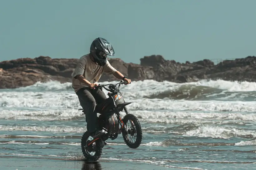 GT54 PRO elektrinis dviratis 1000W važiuoja paplūdimiu per vandenį – galingas bekelės e-dviratis su storomis padangomis, skirtas smėliui, purvui ir sudėtingam reljefui
