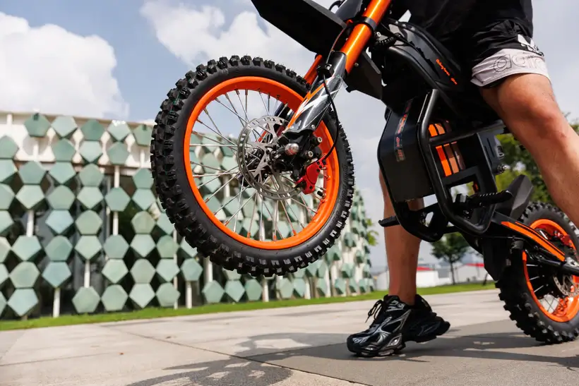 GT54 elektrinis dviratis 1000W su pakeltu priekiniu ratu mieste, stambus priekinio rato ir pakabos vaizdas