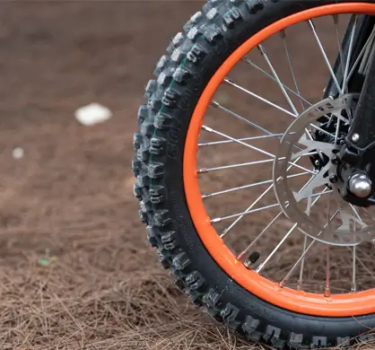 GT54 elektrinis motociklas 1000W – bekelės padanga ir stipinuotas ratas iš arti su giliu protektoriumi geram sukibimui ant smėlio ir žvyro